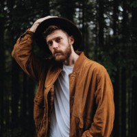 the portrait of a stylish handsome man in a hat in the forest tree background - fashion stock pictures, royalty-free photos & images