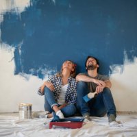 thoughtful couple taking a break from painting their house - home decoration stock pictures, royalty-free photos & images