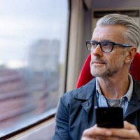 thoughtful man using his phone while riding on a train - travel stock pictures, royalty-free photos & images