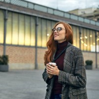thoughtful smiling woman holding disposable cup - fashion stock pictures, royalty-free photos & images
