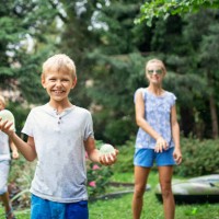 three children having fun throwing water bombs - garden decoration stock pictures, royalty-free photos & images