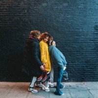 three friends dancing in the city against a black brick wall - fashion stock pictures, royalty-free photos & images