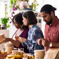 three friends serving takeaway food from delivery - junk food stock pictures, royalty-free photos & images
