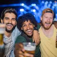three happy young men partying on a music festival at night. - concert stock pictures, royalty-free photos & images