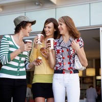three teenage girls drinking take-out coffees and eating cakes - junk food stock pictures, royalty-free photos & images