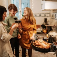 three women drinking wine while preparing christmas dinner at home - home decoration stock pictures, royalty-free photos & images