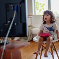 three year old boy eating in front of a television and surprised from what he see - junk food stock pictures, royalty-free photos & images