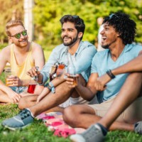 three young men resting and drinking on a music festival. - concert stock pictures, royalty-free photos & images