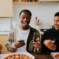 three young people open a box to reveal a full pizza - junk food stock pictures, royalty-free photos & images