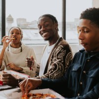 three young people share a pizza together - junk food stock pictures, royalty-free photos & images