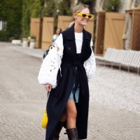 Tin Vcb wears a navy sleeveless coat, denim shorts and a white laced top outside Munthe during the Copenhagen Fashion Week Spring/Summer 2024 on...