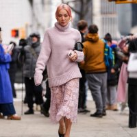 Tina Leung wears gold earrings, light pink turtleneck knit Michael Kors sweater, silver rings, light pink sheer mesh floral Michael Kors midi skirt,...