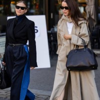 Tine Andrea wears high waisted navy, denim two tone jeans, black blazer, belt, bag & Annabel Rosendahl wears black bag, beige trench coat at Oslo...