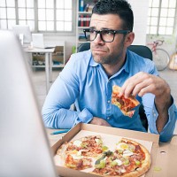 tired businessman eating pizza at the office - junk food stock pictures, royalty-free photos & images