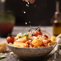 tomato sauce bowl of rigatoni, with human hand, olive oil, and parmisan cheese - food stock pictures, royalty-free photos & images