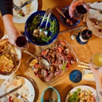 top down shot of guests raising glasses at thanksgiving dinner table - food stock pictures, royalty-free photos & images