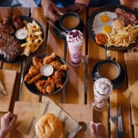 top view, hands and fast food on table at restaurant for dinner or lunch, people with cuisine and catering. burger, fries and milkshake drinks with wings for nutrition and eating meal for supper - food stock pictures, royalty
