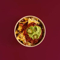 top view of a plate of nachos, traditional mexican food, on a plain maroon background. - junk food stock pictures, royalty-free photos & images
