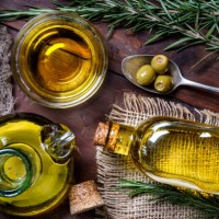 top view of olives and olive oil bottles on table in a rustic kitchen - food stock pictures, royalty-free photos & images