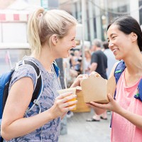 tourists sharing lunch at food market - junk food stock pictures, royalty-free photos & images