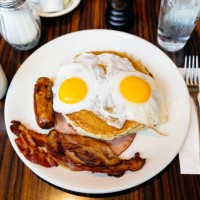 traditional american breakfast with pancakes, fried eggs, bacon, sausage and ham served in a diner - junk food stock pictures, royalty-free photos & images