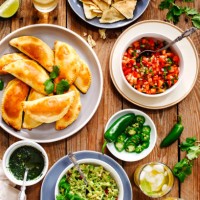 traditional mexican food - meat empanadas with cilantro chimichurri sauce, guacamole, salsa, tortilla chips and mojito - food stock pictures, royalty-free photos & images