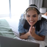 transgender woman watching something on laptop (or on a video call) at home - concert stock pictures, royalty-free photos & images