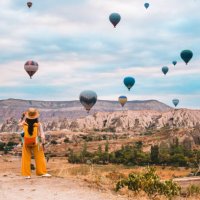 traveler backpacker girl is watching hot air balloons and the fairy chimneys at cappadocia goreme in nevsehir , turkey - travel stock pictures, royalty-free photos & images