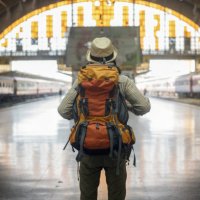 traveler man waits train on railway platform. - travel stock pictures, royalty-free photos & images