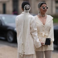Twins Jyoti Babani, Snehal Babani seen wearing glasses decorated with pearls and crystals, head and hair accessories, and a creme white Chanel...