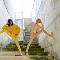two alternative friends posing on steps, wearing yellow and pink jeans clothes - fashion stock pictures, royalty-free photos & images