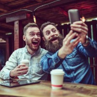 two bearded friends drinking coffee and taking selfie in restaurant - junk food stock pictures, royalty-free photos & images