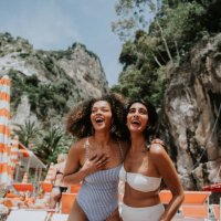 two beautiful young woman look thrilled to be standing on a sunny beach in paradise - travel stock pictures, royalty-free photos & images