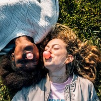 two best friends making a gum bubble lying in the grass - food stock pictures, royalty-free photos & images