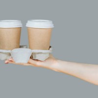 two brown disposable coffee cups on a cardboard rack isolated on a gray background. hygienic cooking or home delivery concept. banner, template, copy space - junk food stock pictures, royalty-free photos & images