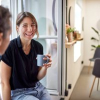 two businesswomen having a coffee break at the window in office - coffee stock pictures, royalty-free photos & images