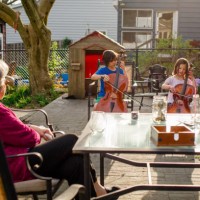 two children give cello concert for grandmother at dinner table - concert stock pictures, royalty-free photos & images