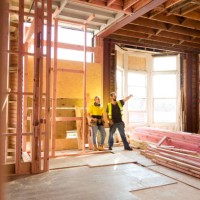 two construction workers talk together inside large house under renovation - home decoration stock pictures, royalty-free photos & images