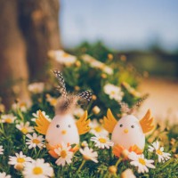 two cute handmade easter eggs in retro look as a sweet cockerel in a bloomy garden - garden decoration stock pictures, royalty-free photos & images