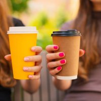 two female twin sisters hands holding recyclable takeaways coffee cup outdoors, close-up - junk food stock pictures, royalty-free photos & images
