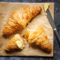 two freshly baked french croissants with butter and a knife - junk food stock pictures, royalty-free photos & images