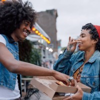 two friends eating pizza on the street - junk food stock pictures, royalty-free photos & images