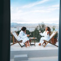 two friends having a good time drinking tea with the scenic view on the balcony - travel stock pictures, royalty-free photos & images