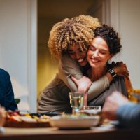 two friends hugging during a dinner celebration - food stock pictures, royalty-free photos & images