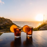 two glasses with cocktails at the table by the ocean during sunset - food stock pictures, royalty-free photos & images