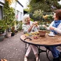 two happy senior women crafting at garden table - garden decoration stock pictures, royalty-free photos & images