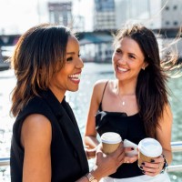 two happy women having a coffee break on a bridge in the city - junk food stock pictures, royalty-free photos & images