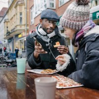 two mature students chatting over pizza slice on lunchbreak together - junk food stock pictures, royalty-free photos & images