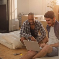 two men moving into a new home, looking at laptop - home decoration stock pictures, royalty-free photos & images