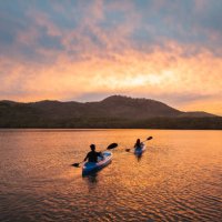 two people kayaking in a lagoon at sunset - travel stock pictures, royalty-free photos & images